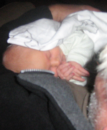 Liten och morfar myser. Liten är två dagar gammal, morfar lite äldre